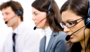 Customer service team working in headsets woman in front.